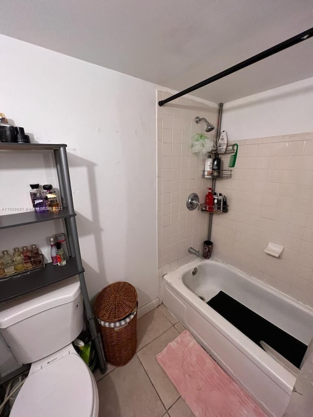 bathroom featuring tiled shower / bath combo, tile patterned floors, and toilet