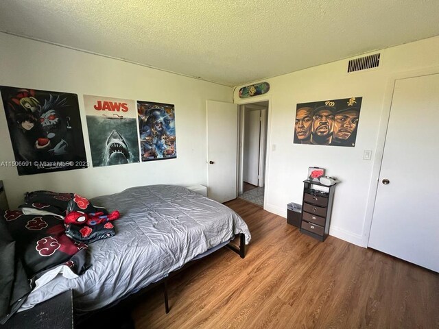 bedroom featuring wood-type flooring and a textured ceiling