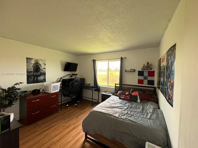 bedroom featuring light hardwood / wood-style flooring and a textured ceiling