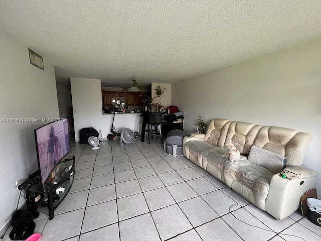 tiled living room featuring a textured ceiling