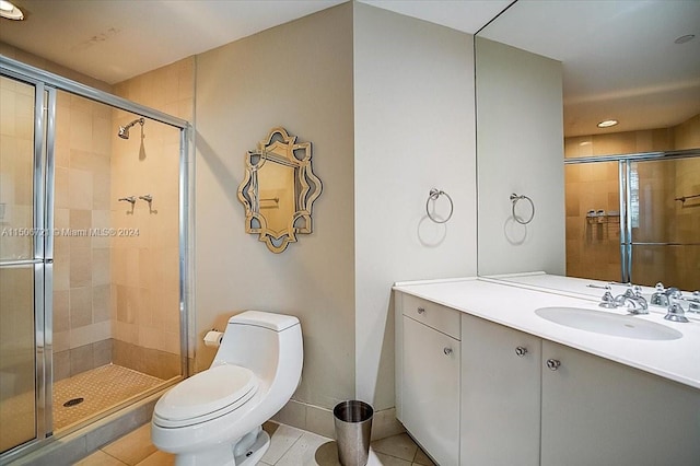 bathroom with a shower with shower door, tile flooring, vanity, and toilet