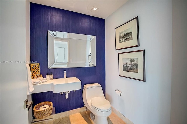 bathroom featuring sink, toilet, and tile floors