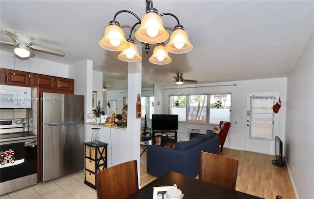 tiled dining space featuring ceiling fan with notable chandelier