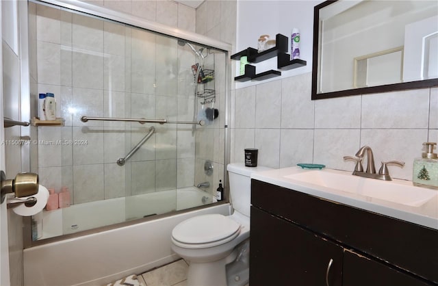 full bathroom with bath / shower combo with glass door, toilet, decorative backsplash, vanity, and tile walls