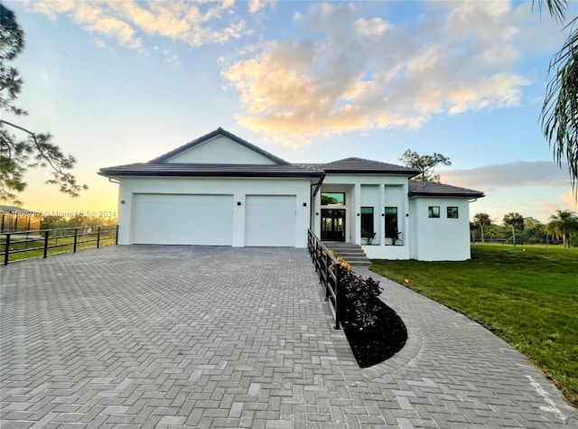 view of front facade with a garage and a lawn