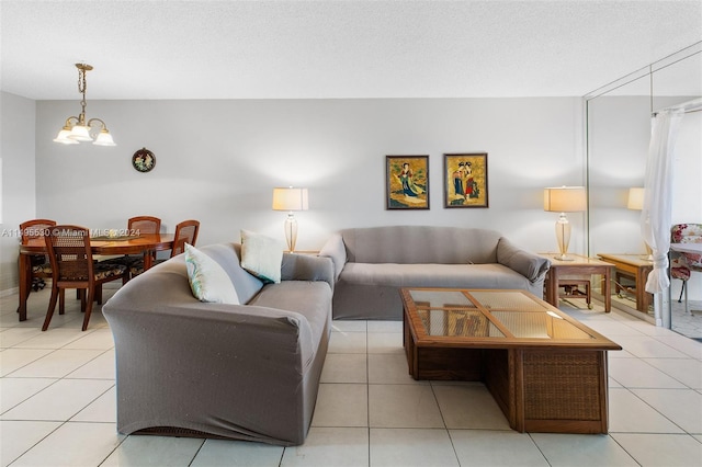 living room featuring light tile patterned flooring, a textured ceiling, and an inviting chandelier