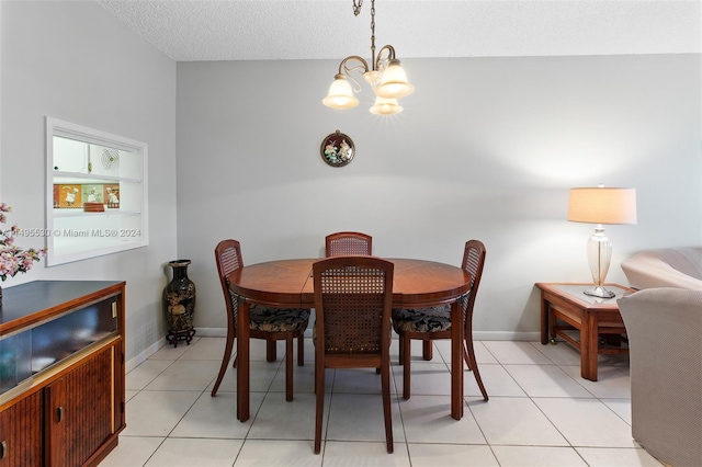 dining area with a textured ceiling, an inviting chandelier, and light tile patterned flooring