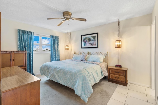 tiled bedroom with ceiling fan and a textured ceiling