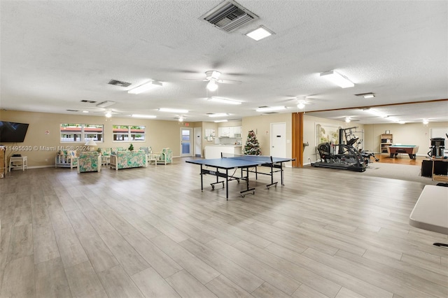 playroom with ceiling fan, light hardwood / wood-style flooring, a textured ceiling, and billiards