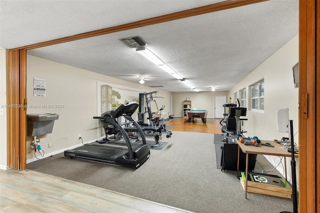 workout room with a textured ceiling and pool table