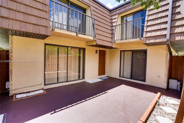 back of property featuring a balcony and a patio