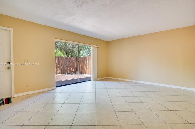 tiled spare room with a textured ceiling