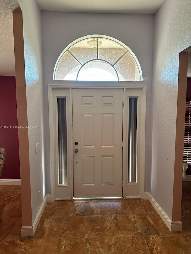 entryway with a wealth of natural light and tile patterned floors