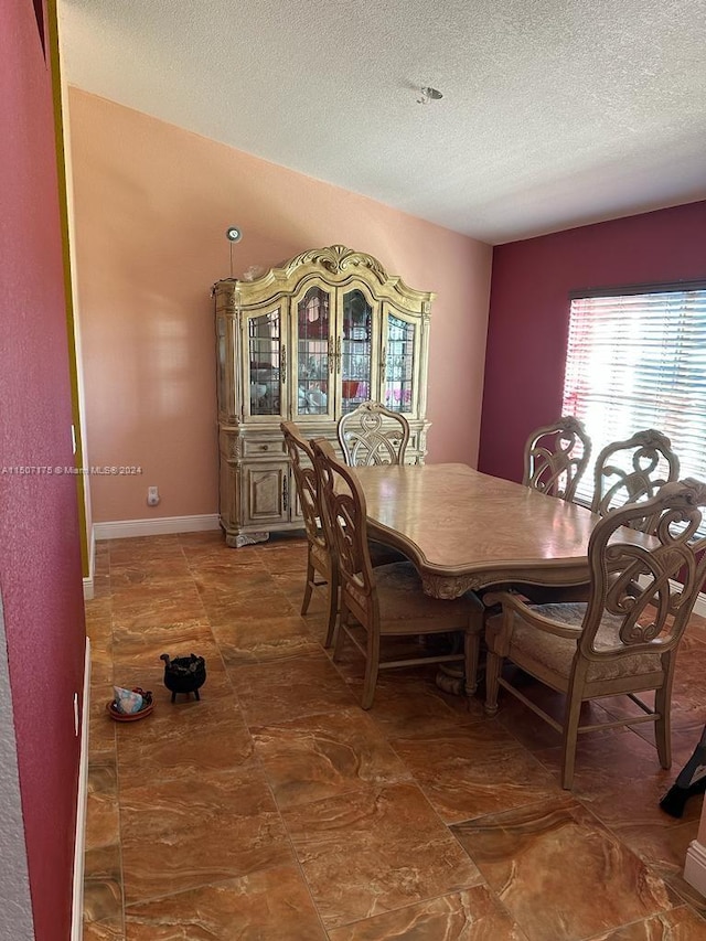 tiled dining area featuring a textured ceiling