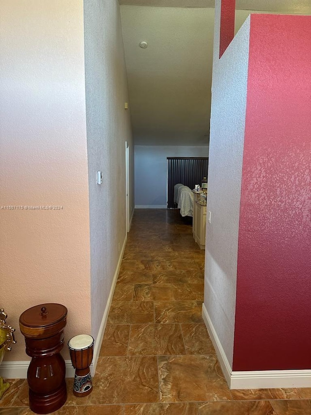 hall featuring dark tile patterned flooring