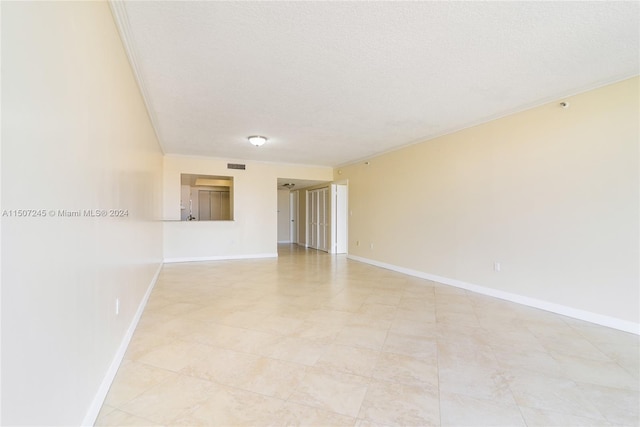 spare room with baseboards and a textured ceiling