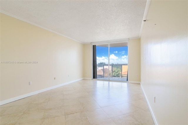 unfurnished room featuring baseboards, a textured ceiling, ornamental molding, and expansive windows