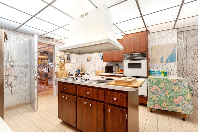 kitchen with white gas cooktop, custom range hood, and light tile patterned floors