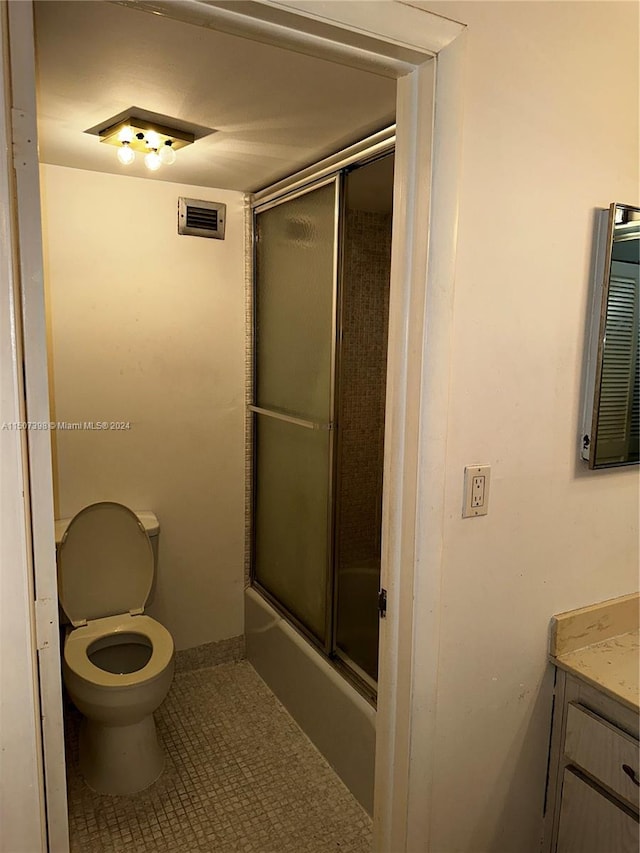 full bathroom with tile patterned floors, vanity, toilet, and combined bath / shower with glass door