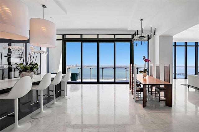 living room featuring a water view, light tile flooring, expansive windows, and a chandelier