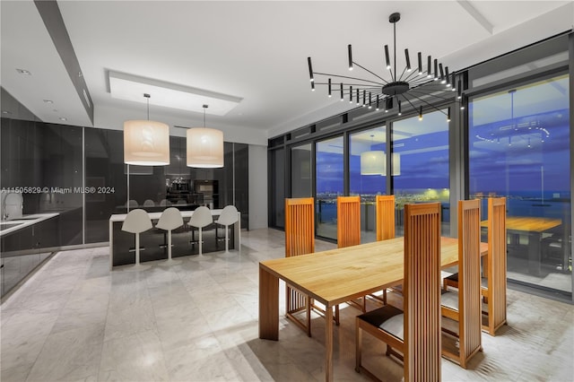 dining area with floor to ceiling windows, light tile flooring, sink, and a chandelier