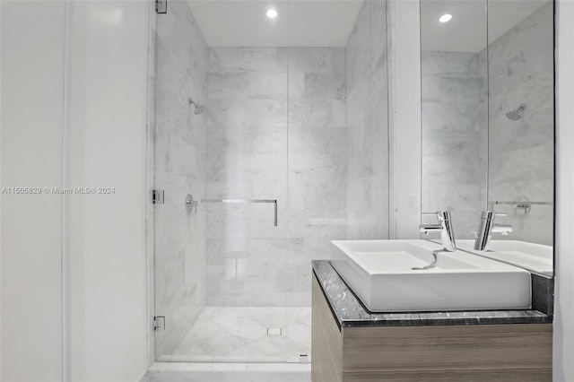 bathroom featuring an enclosed shower, vanity, and tile walls