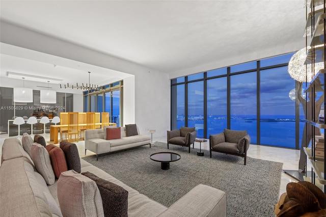 tiled living room with a chandelier and a water view