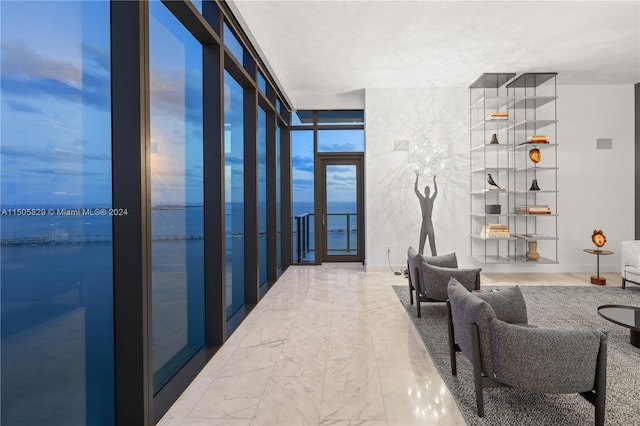 interior space featuring french doors, a water view, and light tile flooring