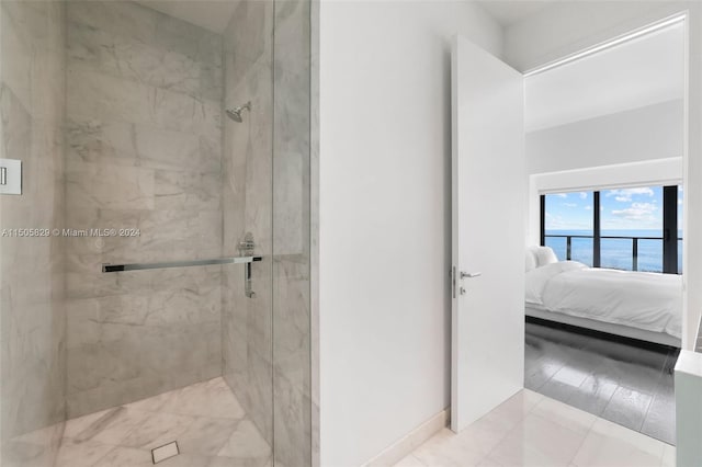 bathroom featuring a water view, a tile shower, and tile flooring