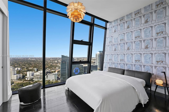 bedroom with an inviting chandelier, floor to ceiling windows, and dark hardwood / wood-style floors