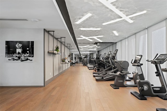 exercise room with light hardwood / wood-style flooring