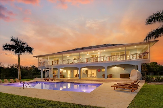 pool at dusk with a patio area