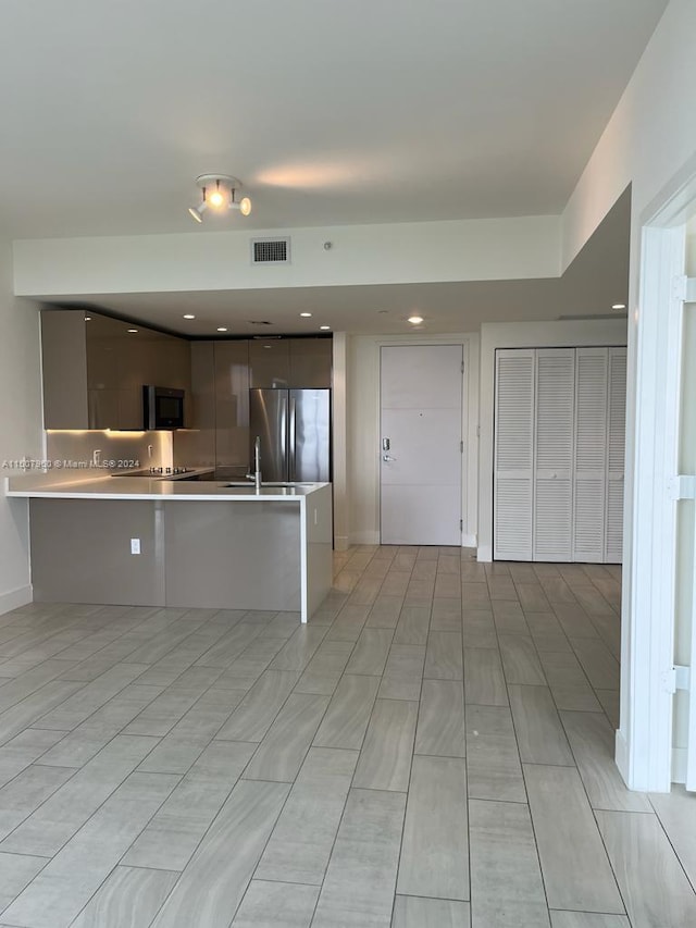 kitchen featuring light tile patterned floors and stainless steel fridge