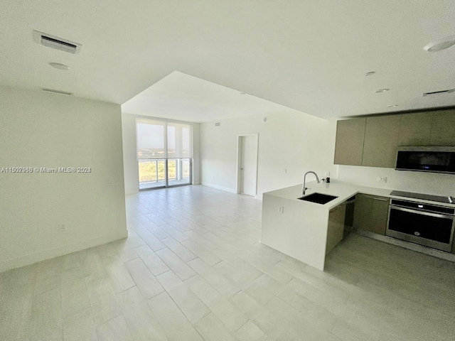 kitchen with stainless steel oven, a wall of windows, gray cabinets, sink, and light tile patterned flooring