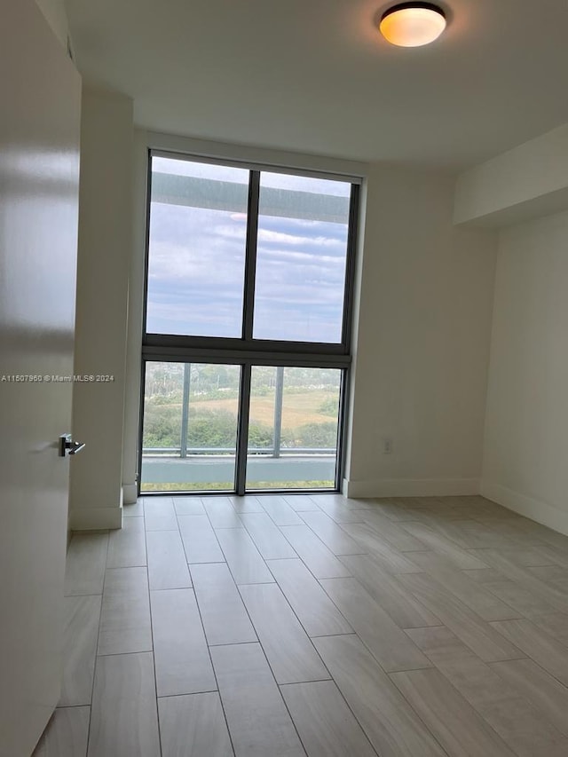 unfurnished room with light tile patterned floors and expansive windows