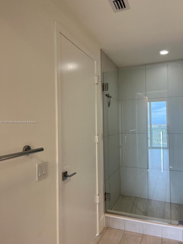 bathroom with walk in shower and tile patterned floors