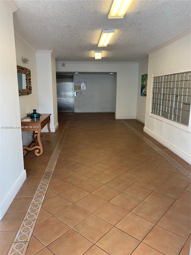 hallway featuring dark tile flooring, crown molding, and a textured ceiling