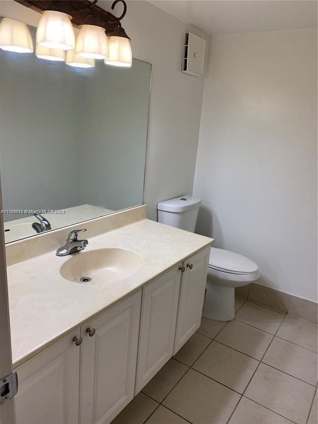 bathroom featuring toilet, tile flooring, and vanity