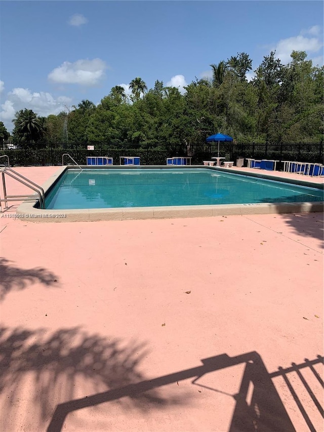711 N Pine Island Rd Unit 111, Plantation, FL 33324 - community pool featuring a patio area and view of wooded area
