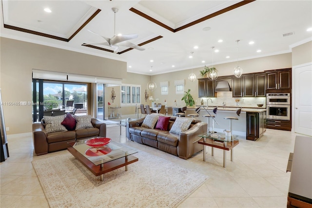 tiled living room with ceiling fan, sink, crown molding, and coffered ceiling