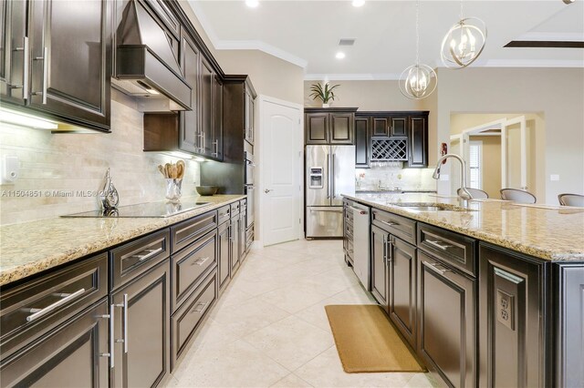 kitchen featuring sink, decorative light fixtures, appliances with stainless steel finishes, a notable chandelier, and custom range hood