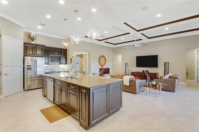 kitchen with high end refrigerator, dark brown cabinets, a kitchen island with sink, sink, and dishwasher