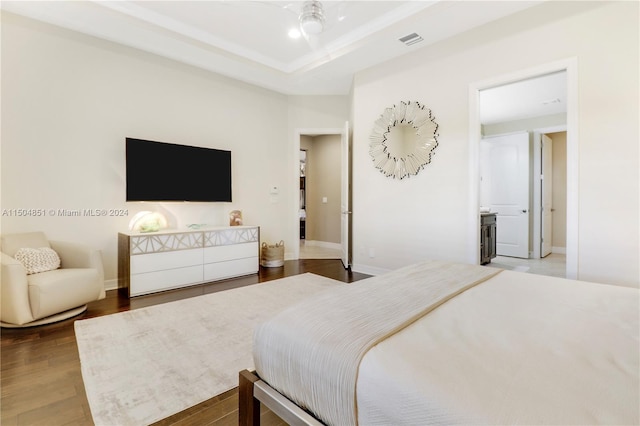 bedroom with a tray ceiling, ceiling fan, and hardwood / wood-style floors