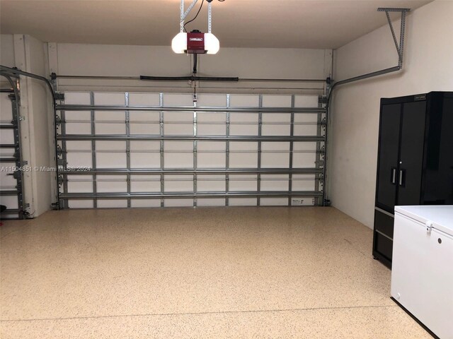 garage with white refrigerator and a garage door opener