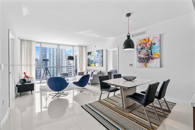 dining area with floor to ceiling windows and light tile floors