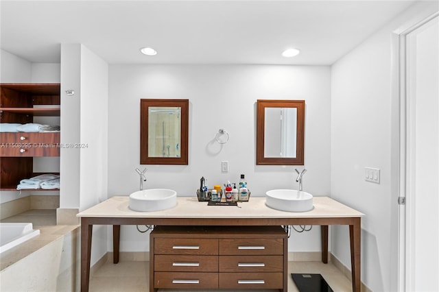 bathroom with tile floors, dual bowl vanity, and a bath to relax in