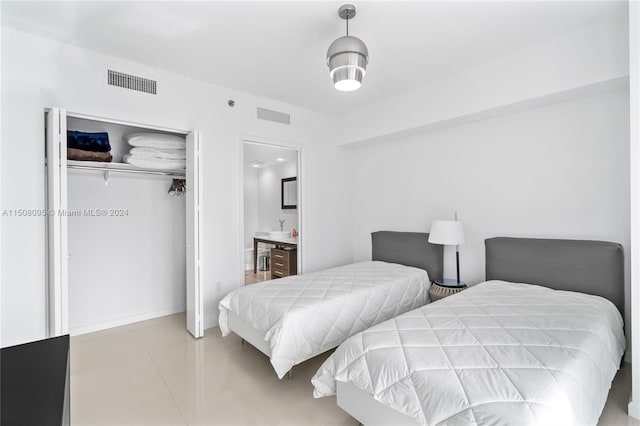 tiled bedroom featuring a closet and connected bathroom