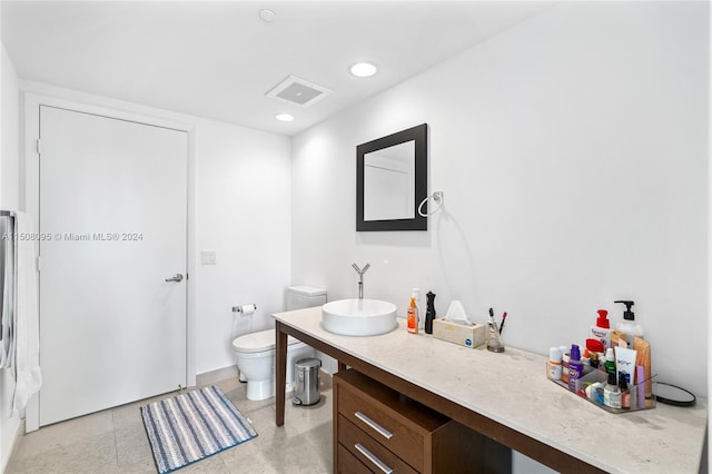 bathroom with vanity, tile floors, and toilet