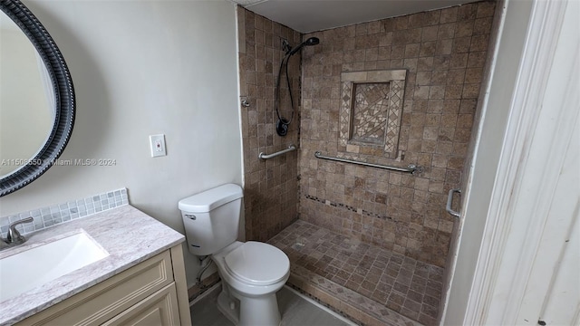 bathroom featuring a shower with door, toilet, and vanity