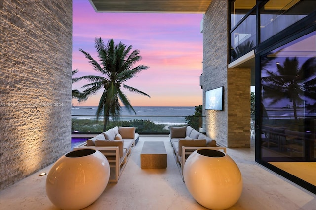 patio terrace at dusk with a water view and outdoor lounge area